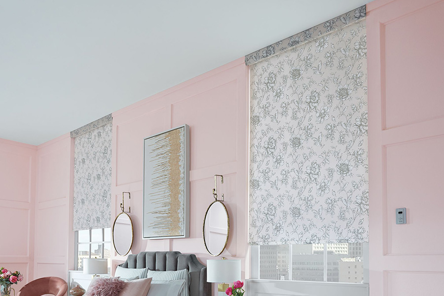 Gray floral roller shades in a pink bedroom